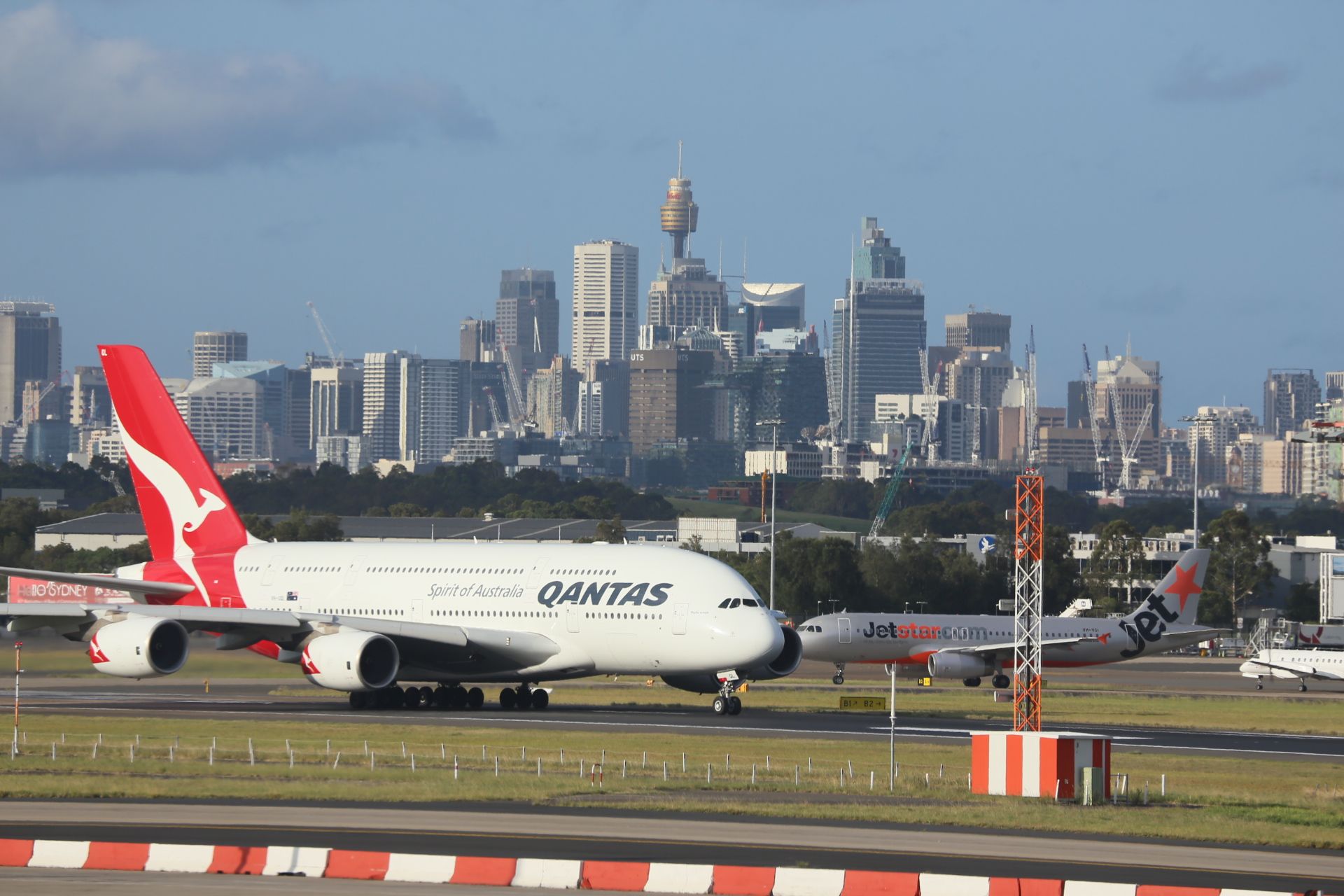 A Qantas A380 taxiing at Sydney Airport with the city skyline behind it